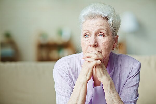 An elderly woman looking worried.